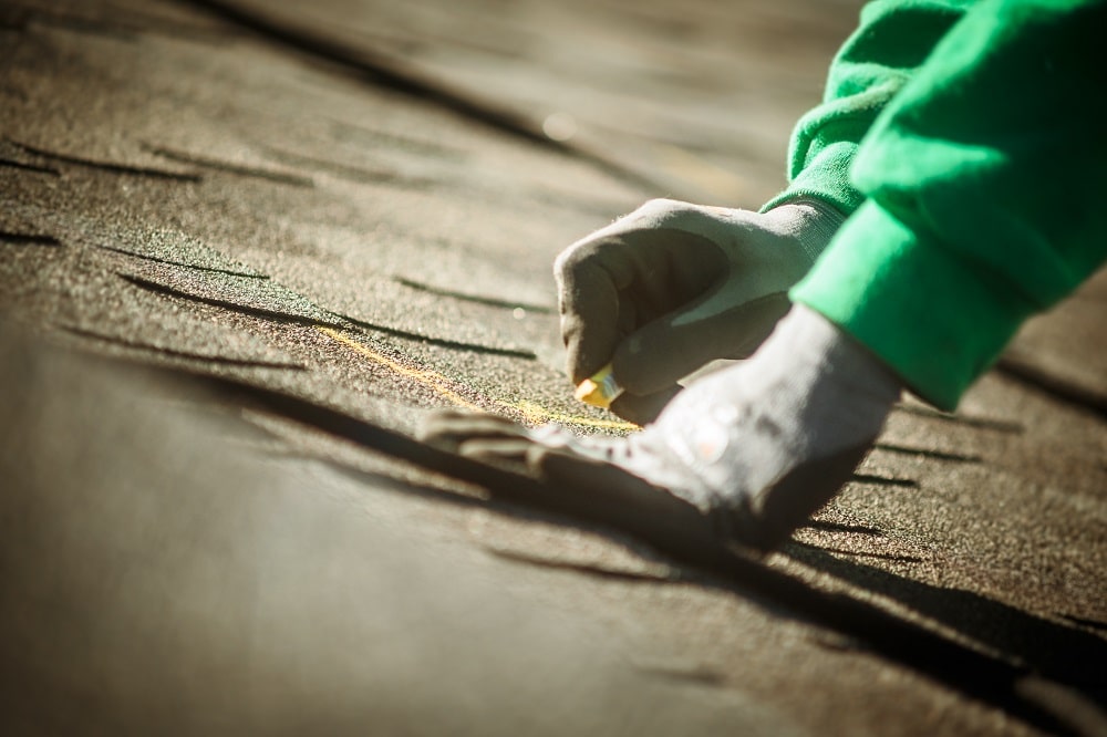 Construction crew member preparing roof for solar panel installation