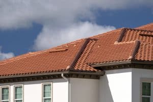 House rooftop covered with yellow ceramic shingles. tiled covering of residential apartment building